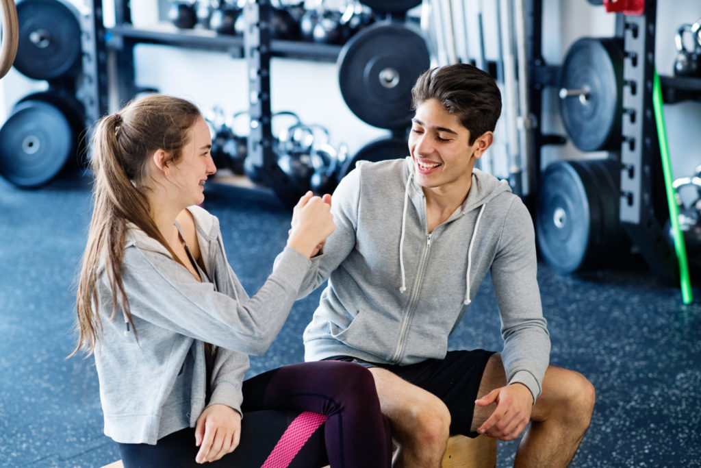 Young fit couple in crossfit gym doing fist pump.